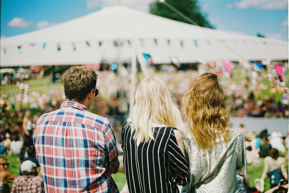 Three people viewing an outdoor event