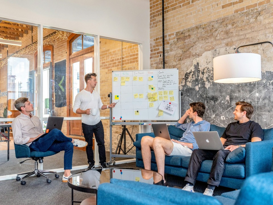 Team discussing ideas, whiteboard in background.